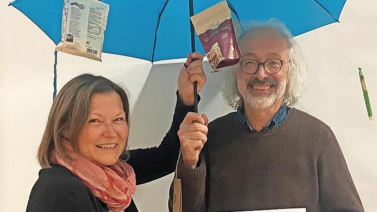 Martina Kirchner überreicht Dirk Hönerlage einen Regenschirm, das zentrale Emblem im neuen Logo des Vereins.