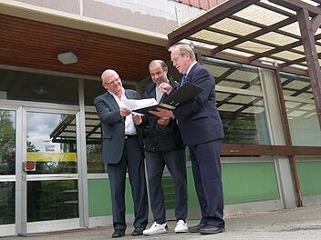 Auf dem Papier schaut das Konzept des "Dorfladens" für Kaltenbrunn schon ganz gut aus - finden (von links) Dieter Scherbel, Jony Salameh und Werner Thomas. Im Hintergrund: Der ehemalige "nah und gut", der mit seinen 330 Quadratmetern Verkaufsfläche für das Projekt in Frage kommen könnte. Foto: Berthold Köhler