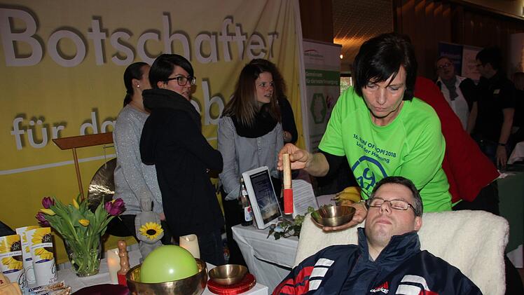 Birgit Schmitt führt bei Tobias Schedel die Kopfklangmassage durch. Foto: Veronika Schadeck