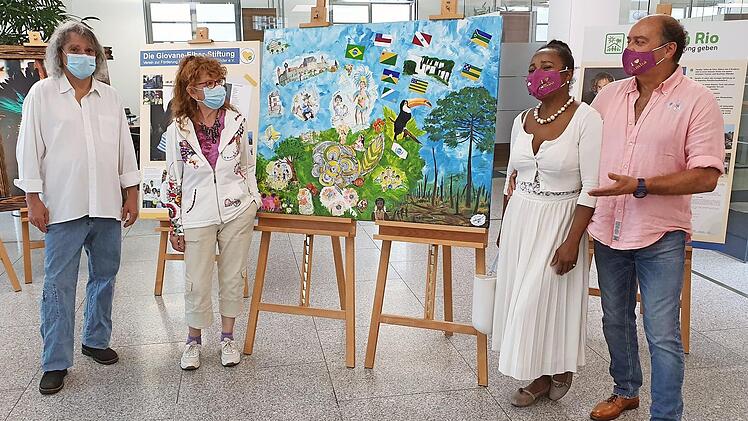 Hans-Jürgen Christ und Monica Güdokeit vom Verein "Treffpunkt Bunte Palette" präsentieren mit Nini und Rolf Beyersdorf von Sambaco (von links) die Collage, die noch bis Anfang September im VR-Finanzplatz Coburg gezeigt wird. Foto: VR-Bank Coburg