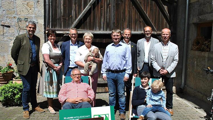 Drei Generationen auf dem Naturlandhof Derleth: In den Bio-Liegest&uuml;hlen - aber keineswegs unt&auml;tig - sind Alfred Derleth und Schwiegertochter Ulrike Derleth mit Sohn Jakob zu sehen, dahinter (von links) Michael Diestel, Margit Ziegler, Eberhard R&auml;der, Margit Derleth mit Enkelin Laura, Michael Derleth, Paul Knoblach (MdL), B&uuml;rgermeister Martin Schmitt und Stefan Fella.  Foto: Regina Vossenkaul