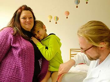 Bei Mama Sandra Janner fühlt sich Leon (6) am wohlsten. Assistenzarzt Philipp Bornschlegl überzeugt sich währenddessen davon, dass der Sechsjährige keine bleibenden Schäden davongetragen hat. Fotos: Nikolas Pelke