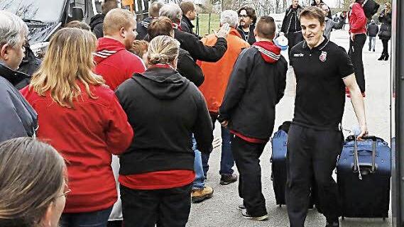 Der Assistent der Teammanagerin, Felix Hilgart (r.), bringt in Hagen die Rollkoffer zum Bus, während sich die mitgereisten Fans von Trainer Andrea Trinchieri verabschieden. Foto: Daniel Löb