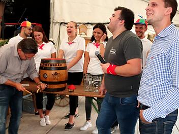 Der Hammer ist wohl viel zu klein: Kerwasburschen und -madli lachen laut auf als Bürgermeister Karsten Fischkal versucht, das Fass trotzdem anzuzapfen.  Fotos: Johanna Blum