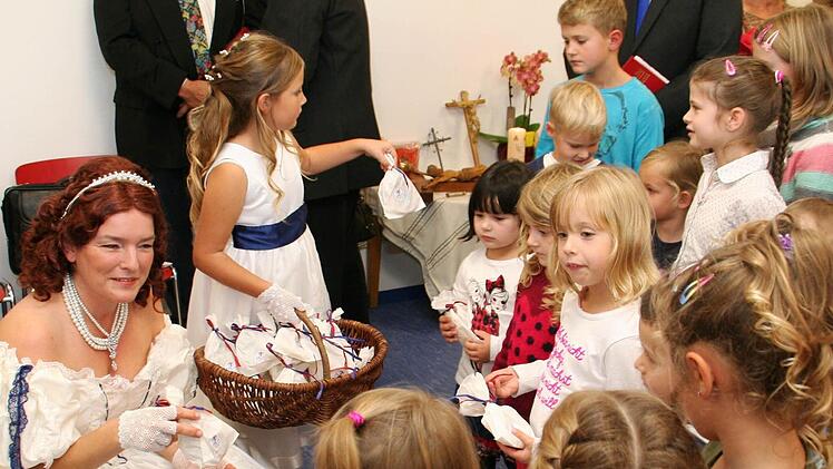 Königin therese, dargestellt von Anja Keller, verteilt Geschenke an die Kinder.