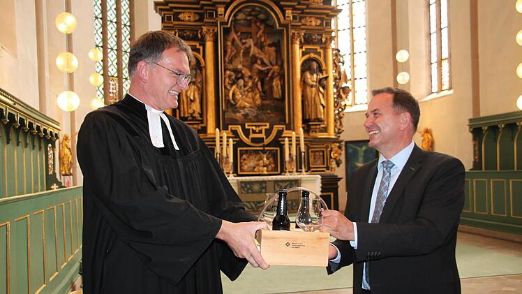 Pfarrer Wolfang Oertel wird Dekan in Münchberg. Schulleiter Alexander Battistella überreicht dem Geistlichen, der an der Adalbert-Raps-Schule unterrichtet hat, zum Abschied ein Geschenk. Foto: Stephan Stöckel
