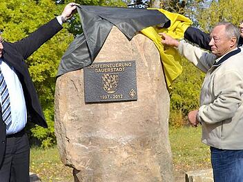 Den Gedenkstein für die Dorferneuerung enthüllen (von links) Wolfgang Kießling, Gunter Müller und Gerold Strobel. Foto: Gabi Betram