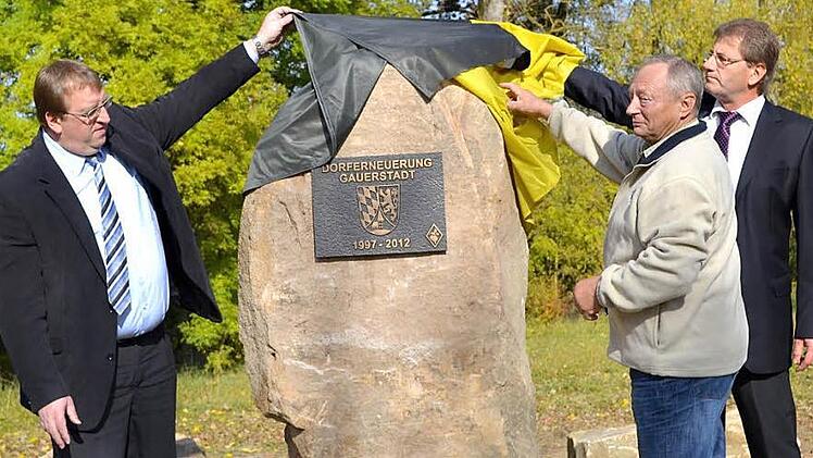 Den Gedenkstein für die Dorferneuerung enthüllen (von links) Wolfgang Kießling, Gunter Müller und Gerold Strobel. Foto: Gabi Betram