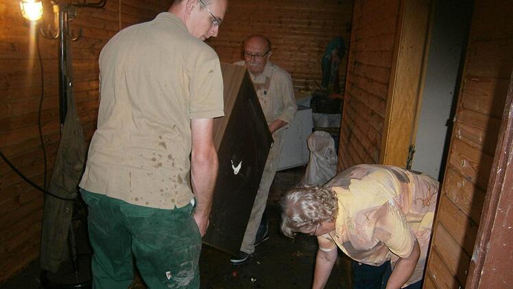 Hermann Kastner (im Hintergrund) räumt mit Ehefrau Gerlinde und seinem Neffen Johannes Wurster nach dem Hochwasser auf. Der Schaden am Anwesen der Familie wird auf 150.000 Euro beziffert.