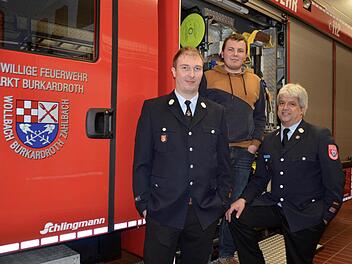 Tobias Kirchner (Mitte) wurde heuer 18 Jahre alt und wurde vom alten und vom neuen Kommandanten der Feuerwehr Bu-Wo-Za, Klaus Kirchner (rechts) und seinem Stellvertreter Thomas Geis, zum Feuerwehrmann ernannt. Hier stehen die Drei an einem Hilfeleistungslöschfahrzeug (HLF) in der Fahrzeughalle des Feuerwehrhauses in Burkardroth. Foto: Kathrin Kupka-Hahn