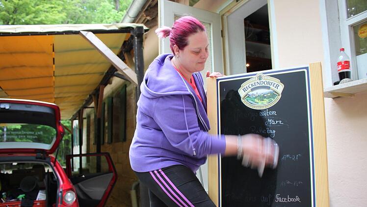 Sabina Sullivan wischt das Wirtshausschild am Schützenkeller ab, bevor sie geht. Foto: Andreas Oswald