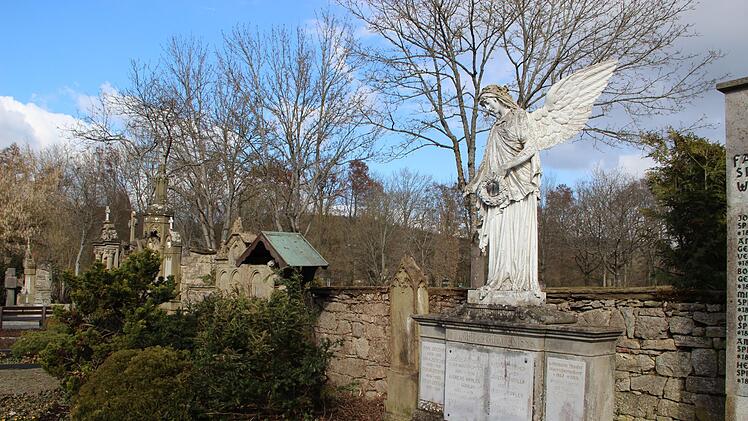 Die Friedhofsmauer ist in diesem Teil des Münnerstädter Friedhofs in einem schlechten Zustand, ebenso wie die historischen Grabmäler. Foto: Heike Beudert