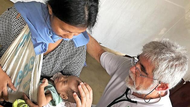 Der fr&auml;nkische Arzt Reinhart Unverricht untersucht im philippinischen Urwald die Fontanelle dieses Mangyanen-Babys.Unverricht/W&ouml;rrlein