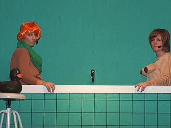 Die Bundeskanzlerin Angela Merkel (Sabine Göbel) und Claudia Roth (Manuela Fischer) diskutieren in Anlehnung an einem Loriot-Sketch in der Badewanne.