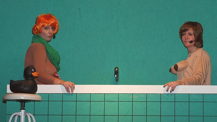 Die Bundeskanzlerin Angela Merkel (Sabine Göbel) und Claudia Roth (Manuela Fischer) diskutieren in Anlehnung an einem Loriot-Sketch in der Badewanne.