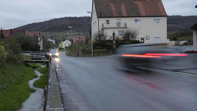 Der Bachlauf (links) soll verrohrt werden. Dann ist Platz für einen Gehsteig, der über dem Flussbett errichtet werden kann. "Dies ist aber kein Ersatz für Tempo 30", betont Bürgermeister Gerhard Amon (CSU). Foto: Josef Hofbauer