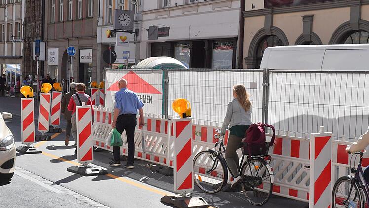 Stadteinwärts sollen an dieser Stelle Fußgänger eigentlich die Straßenseite wechseln (eckiges Schild). Das runde Schild heißt: "Verbot für Fußgänger".