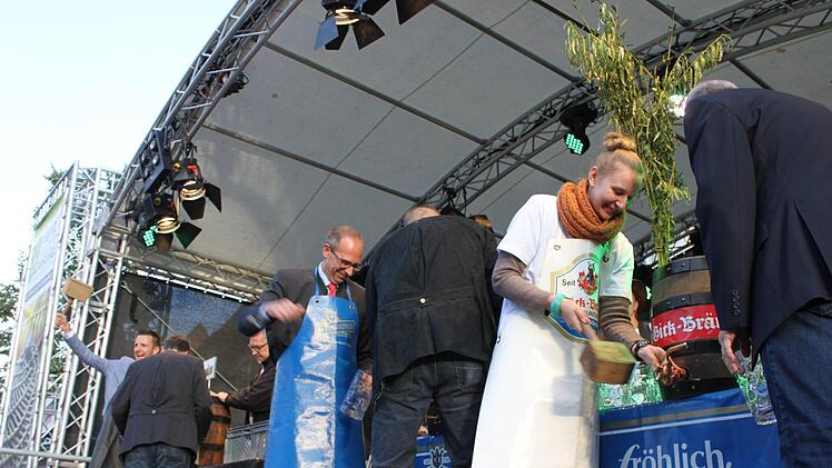 Christin Sell (vorne) beim Bieranstich. Zunächst ging ein Glas zu Bruch, beim zweiten Versuch klappte es. Dahinter (v.r.) Landrat Christian Meißner sowie Bürgermeister Andreas Hügerich, jeweils assistiert von Brauereivertretern.