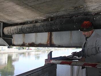 Peter Podlech prüft die Unterseite der Alten Mainbrücke.