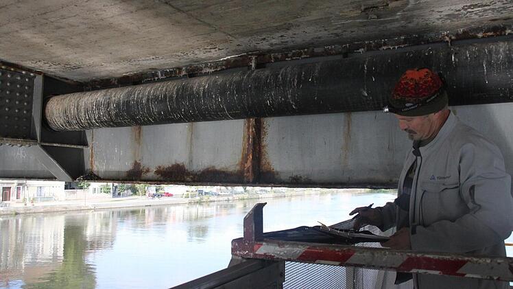Peter Podlech prüft die Unterseite der Alten Mainbrücke.