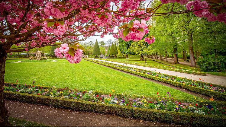 Kunstvolle Skulpturen, symmetrische Blumenbeete und schattige Laubeng&auml;nge laden zum Flanieren im Hofgarten der W&uuml;rzburger Residenz ein.