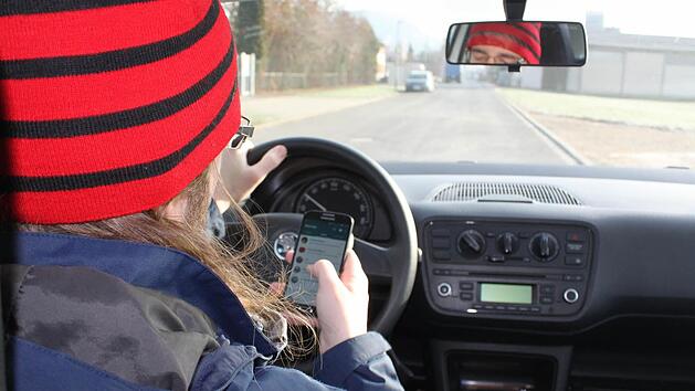 Nicht ok: Nachrichten Checken w&auml;hrend der Fahrt.  Foto: Friederike Stark