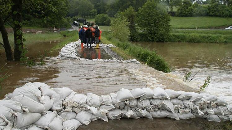 Dass die Aurach über die Ufer tritt und in die Tretzendorfer Weiher fließt, war nicht zu verhindern. Immerhin aber gelingt es den Feuerwehrleuten und anderen Helfern, die Strömungen mit Hilfe von Sandsäcken zu kontrollieren. Fotos: Sabine Weinbeer