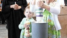 Lara steckt die Osterkerze auf.