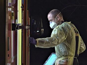 Ein Mitarbeiter des Rettunsgdienstes kommt mit Schutzkleidung aus einem Einsatzwagen. Das Coronavirus breitet sich immer weiter aus. In Bayern gibt es erste bestätigte Infektionen - bald auch in Franken?  Foto: Julian Stähle/dpa