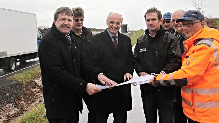 Alfons Schanz (links), Leiter der Tiefbauverwaltung, erläutert den Plan zu Beginn der Baumaßnahme an der Kreisstraße zwischen Untermerzbach und Memmelsdorf zusammen mit (weiter von links), Robert Lutz, Firma ProTerra, Landrat Wilhelm Schneider, Hubert Schramm (Tiefbauamt), Polier Herbert Lang, Zweitem Bürgermeister Siegfried Kirchner und Gunter Jakob, Firma Rädlinger.  Foto: Helmut Will