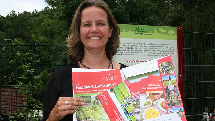 Einen bunten Strauß von Prospekten für den Urlaub in der Fränkischen präsentiert Sandra Schneider, die Leiterin der Tourismuszentrale. Foto: Andreas Oswald