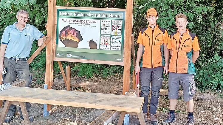 Forstwirtschaftsmeister Michael Fuchs mit den beiden Auszubildenden Noah Kulpa und Niklas Lerch beim Aufbau der Hinweistafeln.