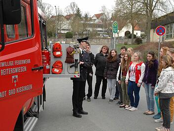 So funktioniert das: Kommandant Bernd Ort erklärt Jugendlichen und Eltern die Bestandteile eines Feuerwehrfahrzeuges. Foto: Peter Klopf