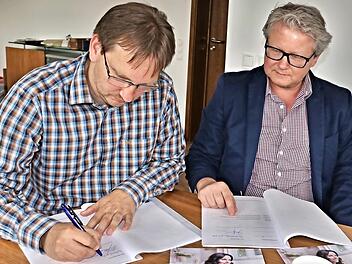 Bürgermeister Wolfram Thein (links) und Uwe Meyer von der Firma Süc-Dacor in Coburg unterzeichnen den Vertrag über den Breitbandausbau im Gemeindegebiet Maroldsweisach. Foto: Helmut Will