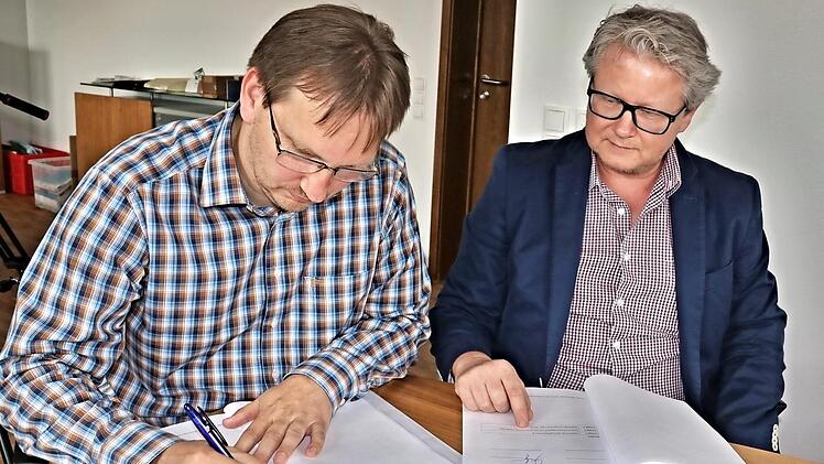 Bürgermeister Wolfram Thein (links) und Uwe Meyer von der Firma Süc-Dacor in Coburg unterzeichnen den Vertrag über den Breitbandausbau im Gemeindegebiet Maroldsweisach. Foto: Helmut Will