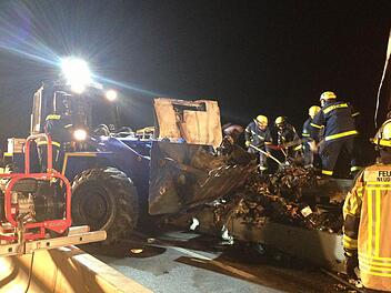 Mit dem Radlader des Kulmbacher THW werden die Überreste der verbrannten Ladung abtransportiert.