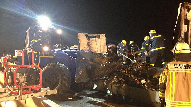 Mit dem Radlader des Kulmbacher THW werden die Überreste der verbrannten Ladung abtransportiert.
