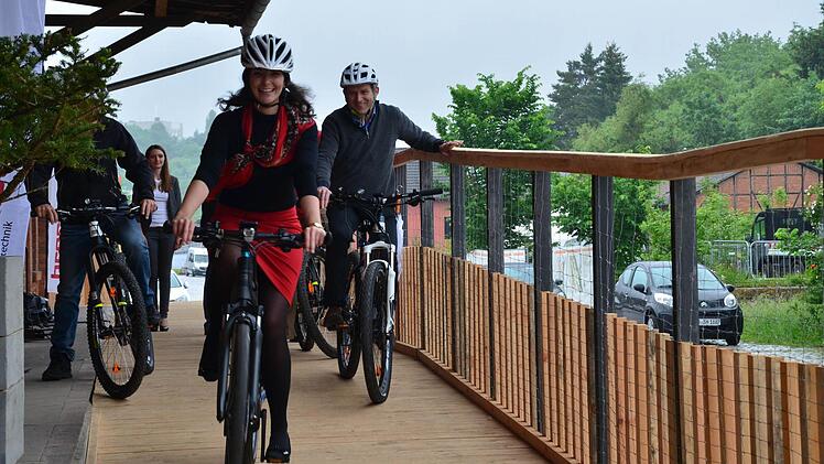 Christina Biegner von den "Jungen Coburgern" und stellvertretender Landrat Rainer Mattern probieren schon mal die E-Bikes aus, die mit einem von Brose entwickelten und produzierten Antriebsmotor ausgestattet sind. Ein solches Rad im Wert von 3000 Euro gibt es bei der "Bike to Work-Challenge" zu gewinnen. Foto: Sandra Hackenberg