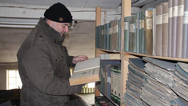 Bürgermeister Werner Stöcker stöbert durch ein Archiv des Rathauses.