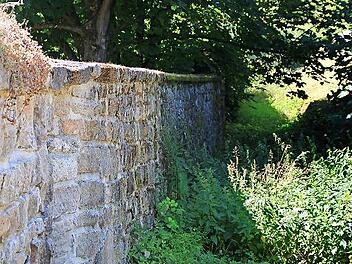 Ziemlich zugewuchert ist der Weg um die Dorfmauer. .