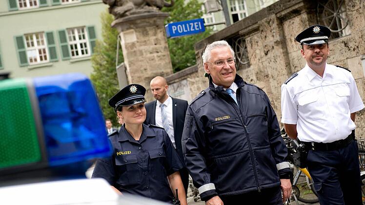 Polizeibeamte präsentieren am 31.07.2014 in München (Bayern) zusammen mit dem bayerischen Innenminister Joachim Herrmann (CSU, M) im Rahmen einer Pressekonferenz die neuen Uniformkonzepte der bayerischen Polizei. Ab August 2014 tragen zunächst etwa 500 Polizistinnen und Polizisten in einem Trageversuch die neue Dienstkleidung. Foto: Sven Hoppe/dpa