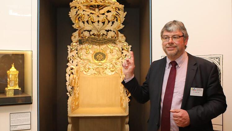 Ausstellungs-Chef Peter Wolf, stellvertretender Direktor des Hauses der Bayerischen Geschichte, mit einem evangelischen Beichtstuhl. Foto: Barbara Herbst