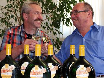 Norbert Bergmann stellt Bürgermeister Lothar Nagel den neuen Gemeindewein vor, einen "Schwarzenauer Rosengarten" Jahrgang 2012. Foto: Pfannes