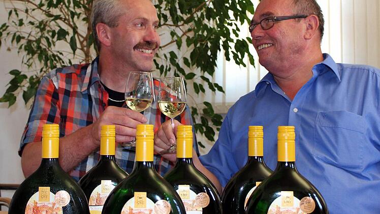 Norbert Bergmann stellt Bürgermeister Lothar Nagel den neuen Gemeindewein vor, einen "Schwarzenauer Rosengarten" Jahrgang 2012. Foto: Pfannes
