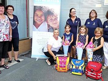 Chloe, Alina und Aya (vorne, von rechts) zeigen stolz ihre neuen Schulranzen. Mit im Bild (von rechts) die Kiwanis-Crew mit Ute Salzwedel, Präsidentin Sigrid Daum, Annegret Pachner und Petra Rehm sowie Martina Bütterich und Marga Schramm von der Tafel. Foto: Dieter Hübner