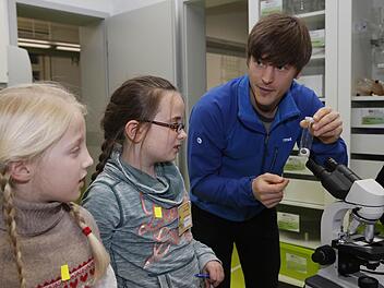 Student Robert Giese zeigt ein echtes Auge eines Schweines. Die Kinder konnten diesmal an der Kinder-Uni einiges über die Sinneswahrnehmungen lernen. Wie hier an der Station "Sehen". Foto: Matthias Hoch