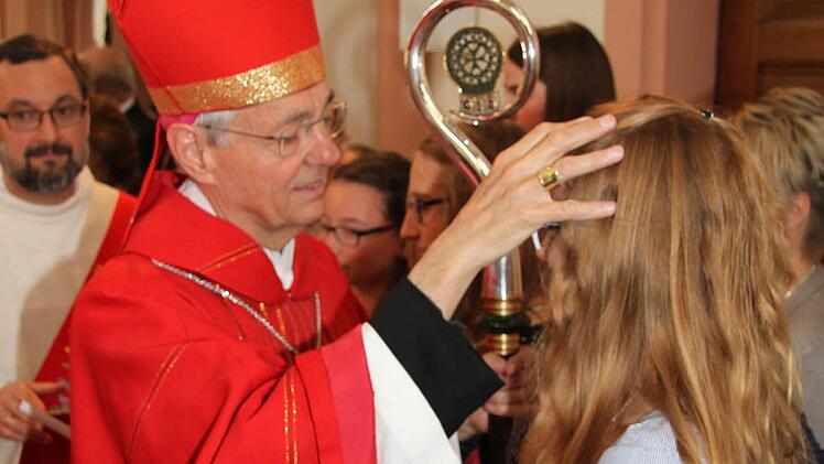 Erzbischof Ludwig Schick zeichnet den Firmlingen mit Chrisamöl das Kreuz auf die Stirn. Foto: Sonny Adam