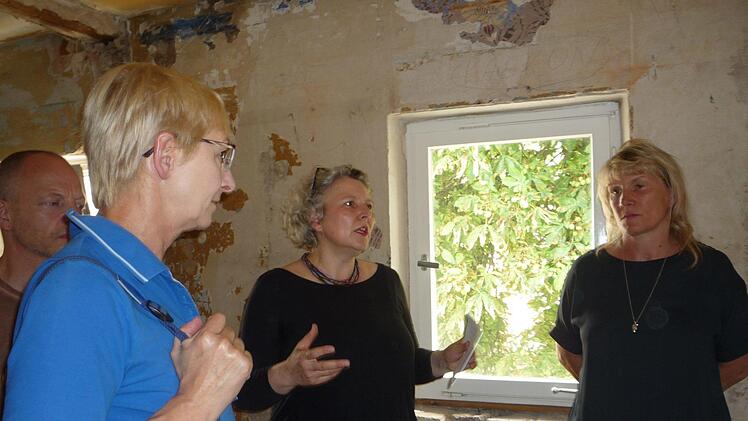 Stadtplanerin und Architektin Michaela Messmer (Mitte) aus Emskirchen erläutert das Projekt an einer Fensterwand, die für einen Balkon teilweise herausgebrochen werden soll. Rechts Investorin Viola Korneli Fotos: Elisabeth Görner