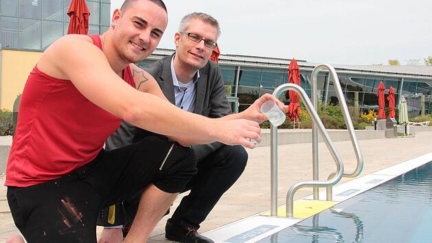 Reines Wasser einschenken kann Schwimmmeister Tobias Folz dem neuen Oberb&uuml;rgermeister Uwe Kirschstein (SPD) bei einer Probeentnahme aus dem gro&szlig;en Au&szlig;enbecken des K&ouml;nigsbades.  Foto. Andreas Oswald