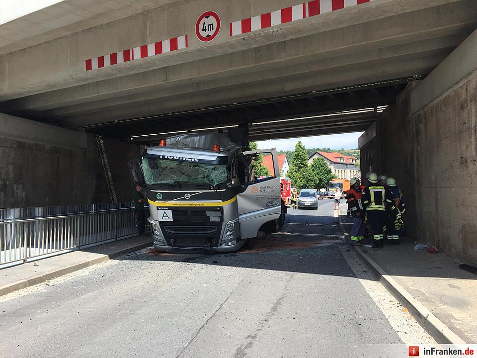 Lkw mit Kranaufbau fährt sich unter Brücke fest